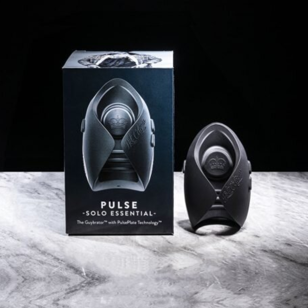 Against a black background, the Hot Octopuss Pulse Solo Essential device is pictured on a marble topped display. It is a curved black device, almost cyclindrical with an opening in the center. A winged like design.